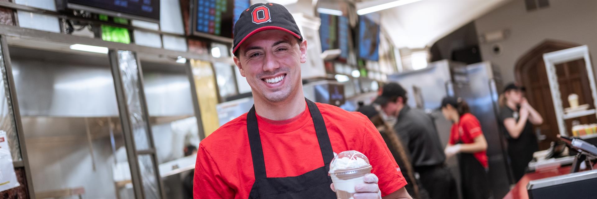 Student holding milkshake, chicken tenders and fries at Mirror Lake Eatery